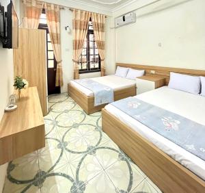 a hotel room with two beds and a television at Ks DŨNG HOA MAI in Sầm Sơn