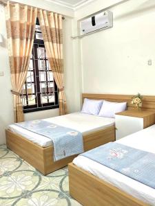 a bedroom with two beds and a window at Ks DŨNG HOA MAI in Sầm Sơn