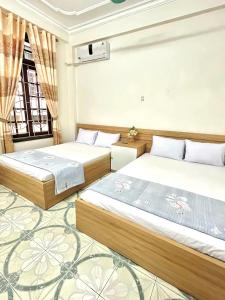 a bedroom with two beds and a window at Ks DŨNG HOA MAI in Sầm Sơn