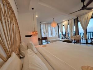a bedroom with a large bed and a living room at Ahangama Surf Club in Ahangama