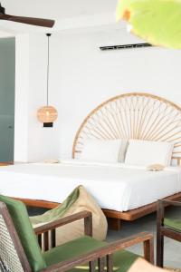 a bedroom with a bed and chairs in a room at Ahangama Surf Club in Ahangama