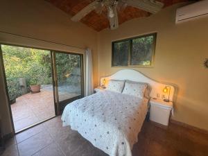 a bedroom with a bed and a sliding glass door at The Sanctuary above Lo De Marcos in Lo de Marcos +59 photos