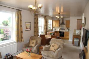 a living room with two chairs and a kitchen at Bannerdale in Penrith