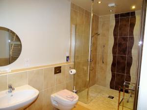 a bathroom with a shower and a toilet and a sink at Bannerdale in Penrith