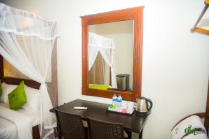a bedroom with a table and a mirror and a bed at Om Hotel in Unawatuna