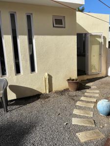 a house with a stone walkway in front of it at Studio tout confort avec piscine pour les amoureux des toutous in Roches Noires +15 photos