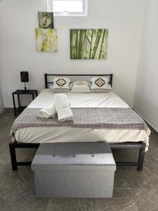 a bed with two pillows on it in a bedroom at Studio tout confort avec piscine pour les amoureux des toutous in Roches Noires