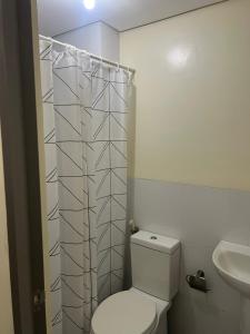 a white bathroom with a toilet and a sink at Studio 7 in Manila
