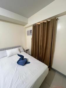 a white bed with a blue towel on it at Studio 7 in Manila
