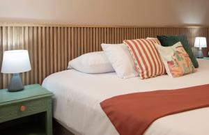 a hotel room with a bed with pillows and a lamp at Lima Atelier Boutique in Lima