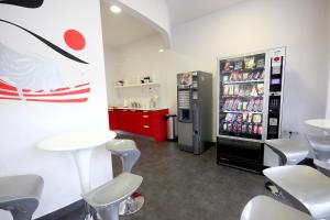 pokój z lodówką, stołami i krzesłami w obiekcie Botxo Gallery - Youth Hostel Bilbao w mieście Bilbao