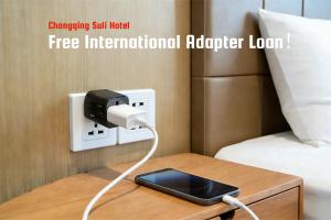 a ipod plugged into a electrical outlet next to a bed at Suli Hotel Chongqing,1 Min Walk to Metro,Near Jiefangbei&Hongya Cave,International guest-friendly,Free Self-Service Laundry,Free High-Speed WiFi,Free Chinese Tea,Free Travel Advice in Chongqing +33 photos