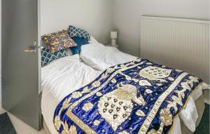 a bed with a blue and white blanket on it at Lovely Home In Simrishamn With Wifi in Simrishamn +23 photos