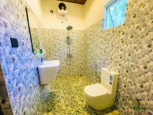 a bathroom with a toilet and a sink at Om Hotel in Unawatuna