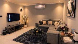 a living room with a couch and a tv at Happy Villa هابي فيلا in Al Khobar