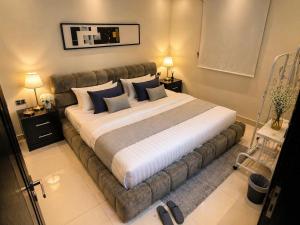 a large bed in a room with two night stands at Happy Villa هابي فيلا in Al Khobar