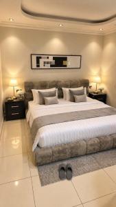 a large bedroom with a large bed with two lamps at Happy Villa هابي فيلا in Al Khobar