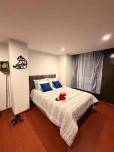 a bedroom with a large bed with a red stuffed animal on it at Apartamento T Premium in Ipiales +14 photos