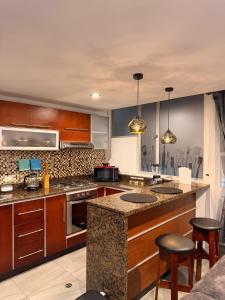 a kitchen with wooden cabinets and a island with bar stools at Apartamento T Premium in Ipiales