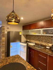 a kitchen with wooden cabinets and a refrigerator at Apartamento T Premium in Ipiales
