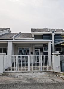 a house with a white fence in front of it at Homestay Seri Damai in Juasseh