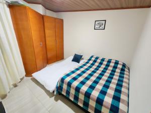 a bedroom with a bed with a checkered blanket at Apartaestudio equipado en Duitama sector UPTC in Duitama