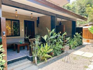 a house with a porch with plants in front of it at Hidden Garden Villa in El Nido