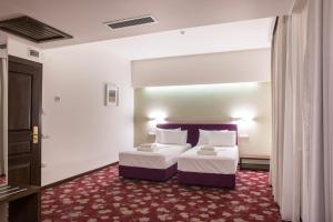A bed or beds in a room at Hotel Relax Craiova