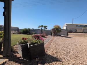 two flower pots on a pole with flowers in them at The Flat on Muddy in Moonta