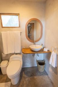 a bathroom with a toilet and a sink and a mirror at Los Amigos Ecoturismo y Reserva Natural in Catemaco +51 photos
