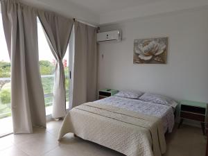 a bedroom with a bed and a large window at Frente a Termas in Federación
