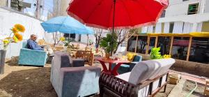 a man sitting in a chair under a red umbrella at T-Suru Hotel & Cafe Leh in Leh