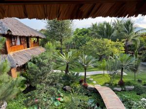 a garden with a path leading to a house at Núi Dinh Stilt House - Phú Mỹ in Ấp Long Cát