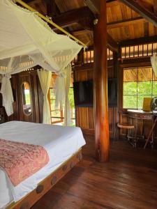 a bedroom with a bed and a table in a room at Núi Dinh Stilt House - Phú Mỹ in Ấp Long Cát +26 photos