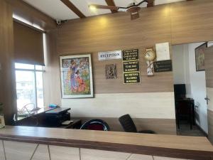 a waiting room with a counter and signs on the wall at Hotel Centre Point in Gorakhpur