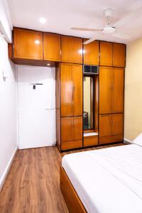 a bedroom with a bed and wooden cabinets at Celestial crest in Pune