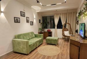 a living room with a green couch and a table at Celestial crest in Pune