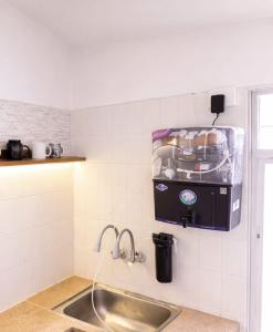 a kitchen with a sink and a dispenser on the wall at Celestial crest in Pune