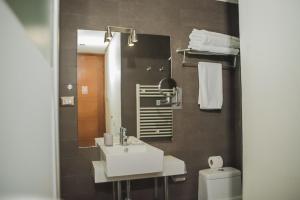 a bathroom with a sink and a mirror and a toilet at Hotel Boutique 17 in Valparaíso