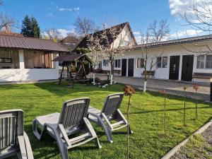 a yard with three chairs and a swing at Pensiunea Beatrice in Sovata