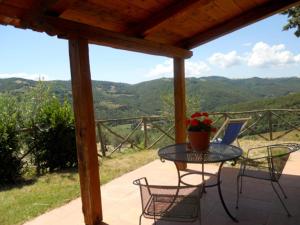 a patio with a table and chairs and a view at Farmhouse in Monte Santa Maria Tiberina with garden in Monte Santa Maria Tiberina +32 photos