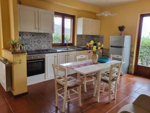 a kitchen with a table and chairs and a refrigerator at Farmhouse in Monte Santa Maria Tiberina with garden in Monte Santa Maria Tiberina