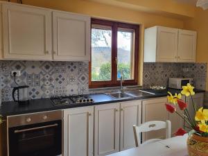 a kitchen with white cabinets and a sink and a window at Farmhouse in Monte Santa Maria Tiberina with garden in Monte Santa Maria Tiberina