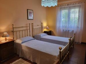 two beds in a bedroom with a window at Farmhouse in Monte Santa Maria Tiberina with garden in Monte Santa Maria Tiberina