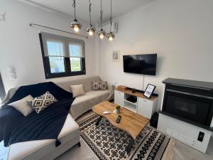 a living room with a couch and a flat screen tv at Eunoia Homestay & BnB - Loutra Pozar, Aridaia in Aridaia