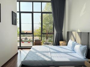a bedroom with a bed and a large window at Tứ Thiên Homestay in Ấp Phú Tịnh (2)