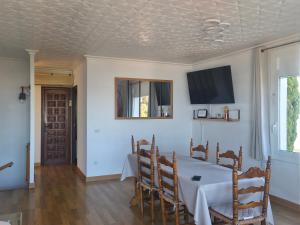 a dining room with a table and a tv on the ceiling at Puig Rom Pau Vila in Roses