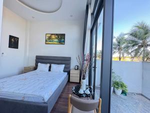 a bedroom with a bed and a large window at Tứ Thiên Homestay in Ấp Phú Tịnh (2)