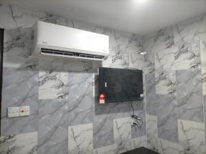 a room with a tv on a marble wall at ARK Port Dickson Seafront Hotel in Port Dickson