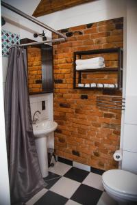 a bathroom with a sink and a brick wall at Willa Skalite in Szczyrk